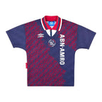 Voorkant van het Ajax uitshirt 1994/1995 van Umbro, donkerblauw voetbalshirt met rood patroon, ABN AMRO-sponsor, Ajax-clublogo en rood-wit-blauwe kraag.