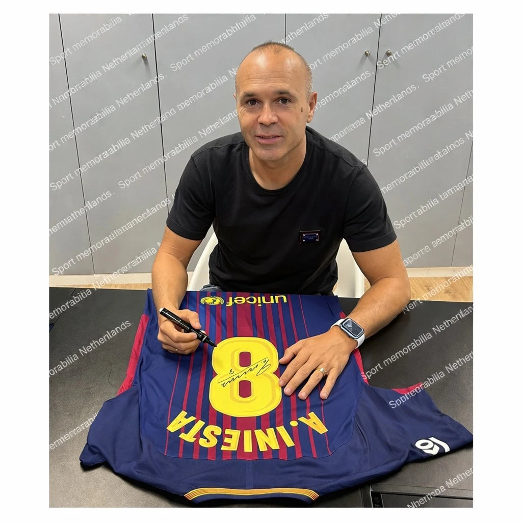 Foto van Andrés Iniesta tijdens het signeren van een FC Barcelona shirt. Authentiek gesigneerd voetbalshirt met certificaat van echtheid – Sport Memorabilia Netherlands.