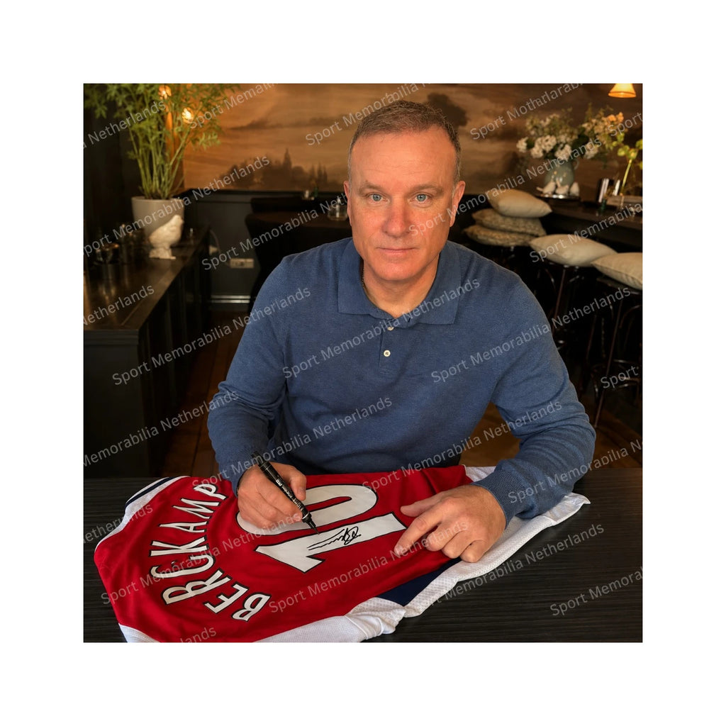 Dennis Bergkamp with a signed official Arsenal 2024-25 home football shirt during a private signing session.