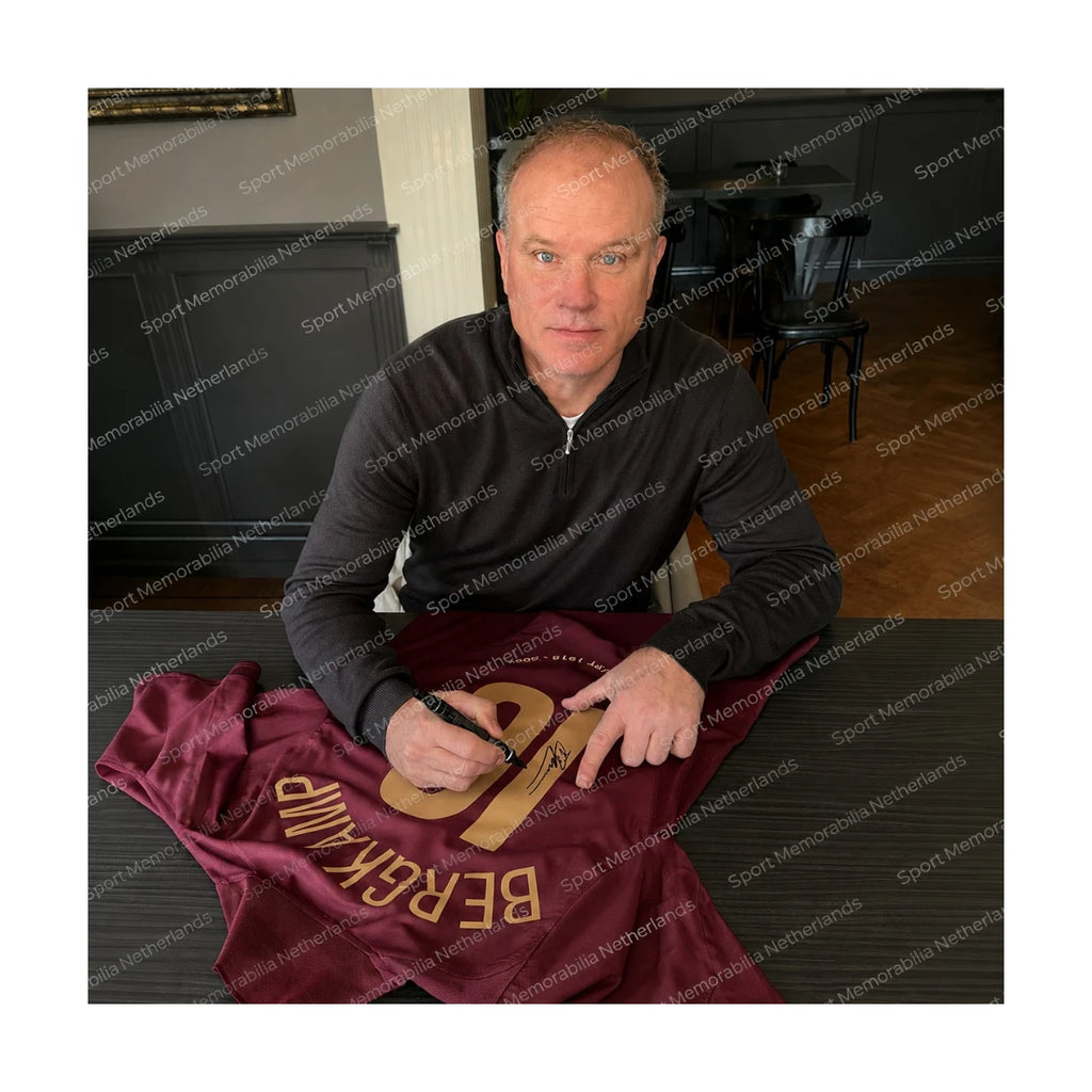 Dennis Bergkamp signing an official Arsenal 2005-06 Highbury football shirt during a private signing session.