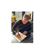 Dennis Bergkamp signing an official replica Holland 1994 home football shirt during a private signing session.