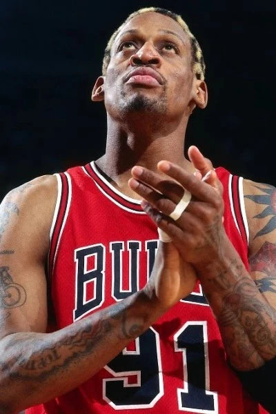 Dennis Rodman in een rood Chicago Bulls nummer 91 basketbalshirt met zichtbare tatoeages.