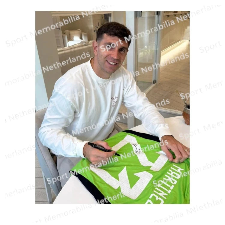 Signing proof of Emiliano Martínez signing a green Argentina goalkeeper shirt during a private signing session.