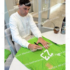 Signing proof of Emiliano Martínez signing a green Argentina goalkeeper shirt during a private signing session.
