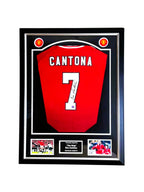 Ingelijst rood Manchester United nummer 7 voetbalshirt gesigneerd door Eric Cantona met twee voetbalfoto’s.
