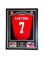 Ingelijst rood Manchester United nummer 7 voetbalshirt gesigneerd door Eric Cantona met twee voetbalfoto’s.
