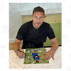 Francesco Totti tijdens een signeermoment met een gesigneerde Italië voetbalfoto als bewijs van de handtekening