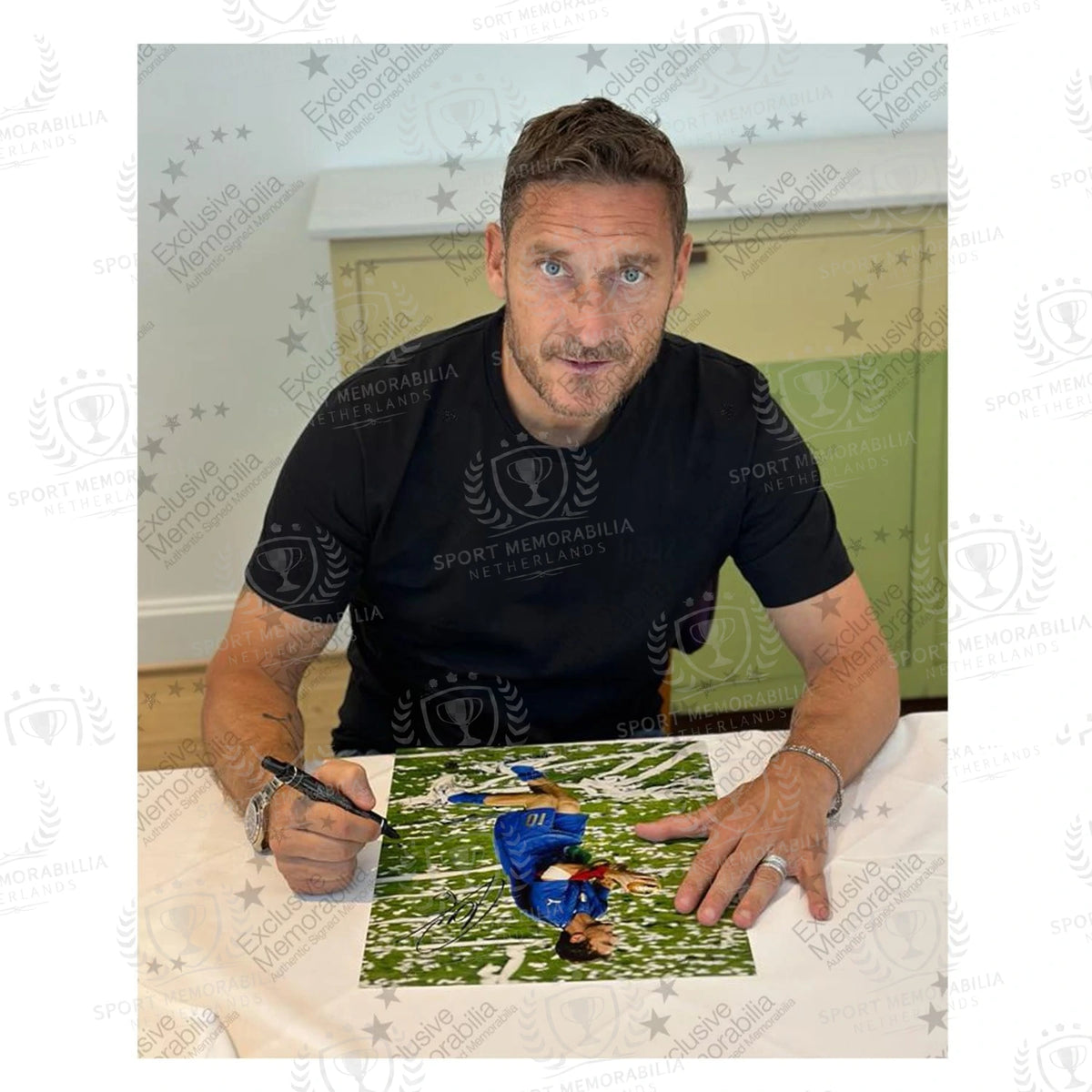 Francesco Totti tijdens een signeermoment met een gesigneerde Italië voetbalfoto als bewijs van de handtekening
