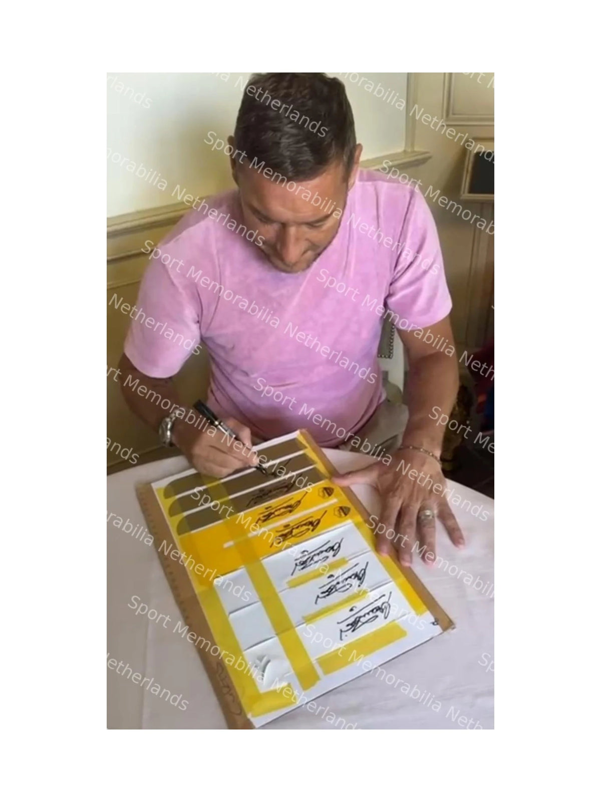 Signing proof of Francesco Totti autographing multiple football memorabilia items.