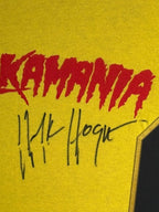 Detail van de handtekening van Hulk Hogan op een geel Hulkamania-shirt.