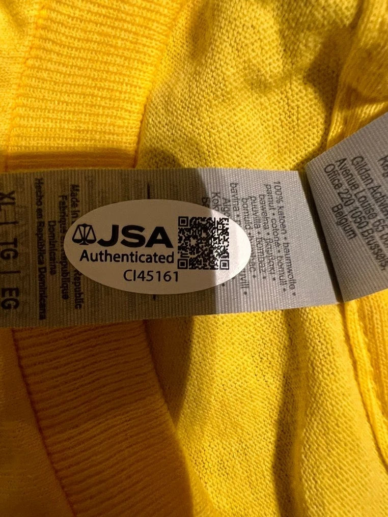 Detail van de JSA-authenticiteitssticker op het gesigneerde gele Hulkamania-shirt van Hulk Hogan.