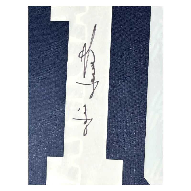 Detailfoto van de handtekening van Jari Litmanen op het witte rugnummer 10 van een donkerblauw Ajax uitshirt 1994/1995, gesigneerd met zwarte stift.