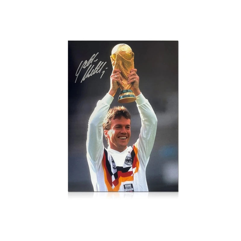 Gesigneerde voetbalfoto van Lothar Matthäus met de WK-trofee voor Duitsland.
