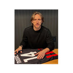 Luka Modrić signing an AC Milan 2025-26 home football shirt during a private signing session.