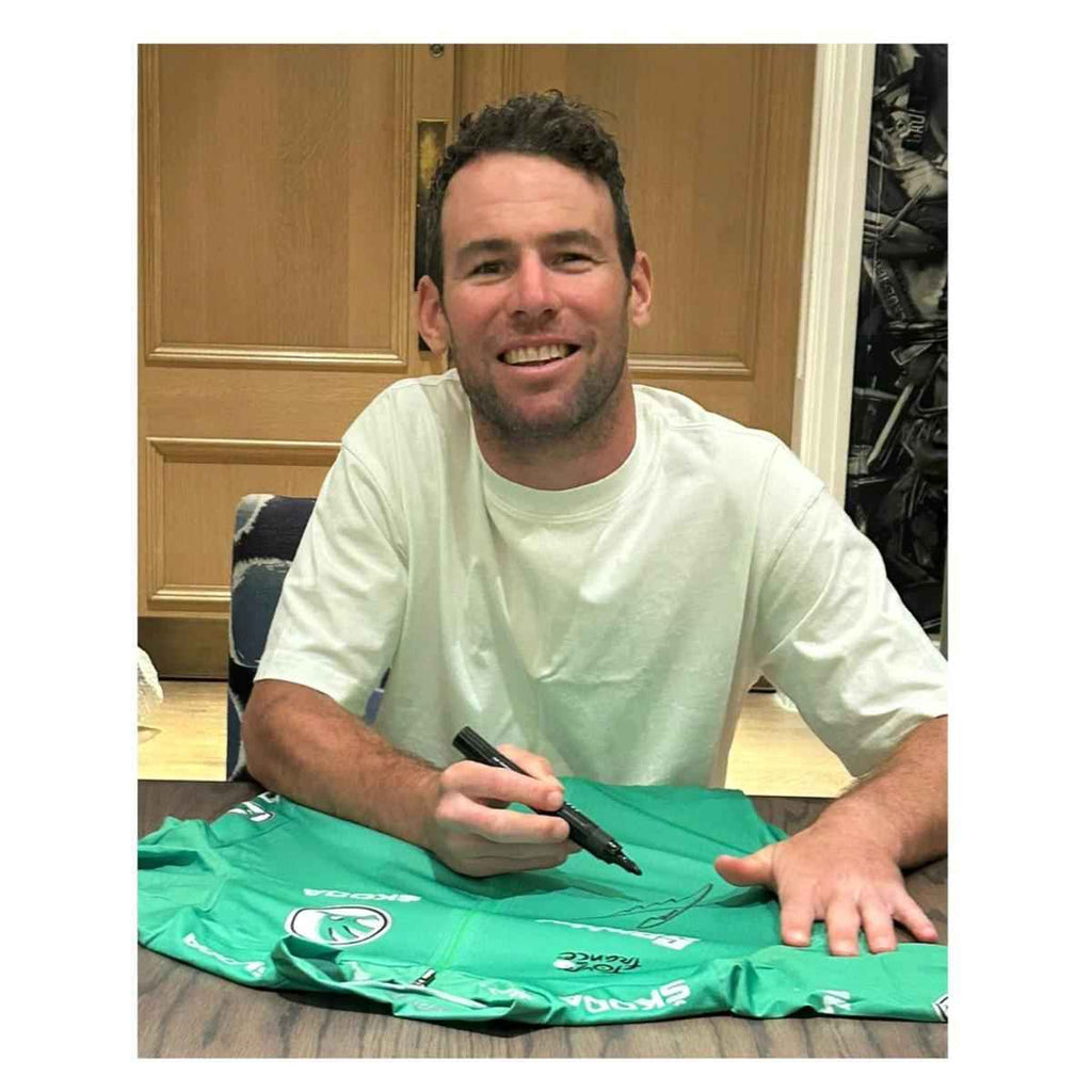 Mark Cavendish tijdens het signeren van een groen Tour de France wielershirt.