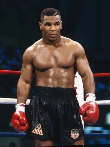 Mike Tyson in de boksring met rode bokshandschoenen en zwarte boksshort.
