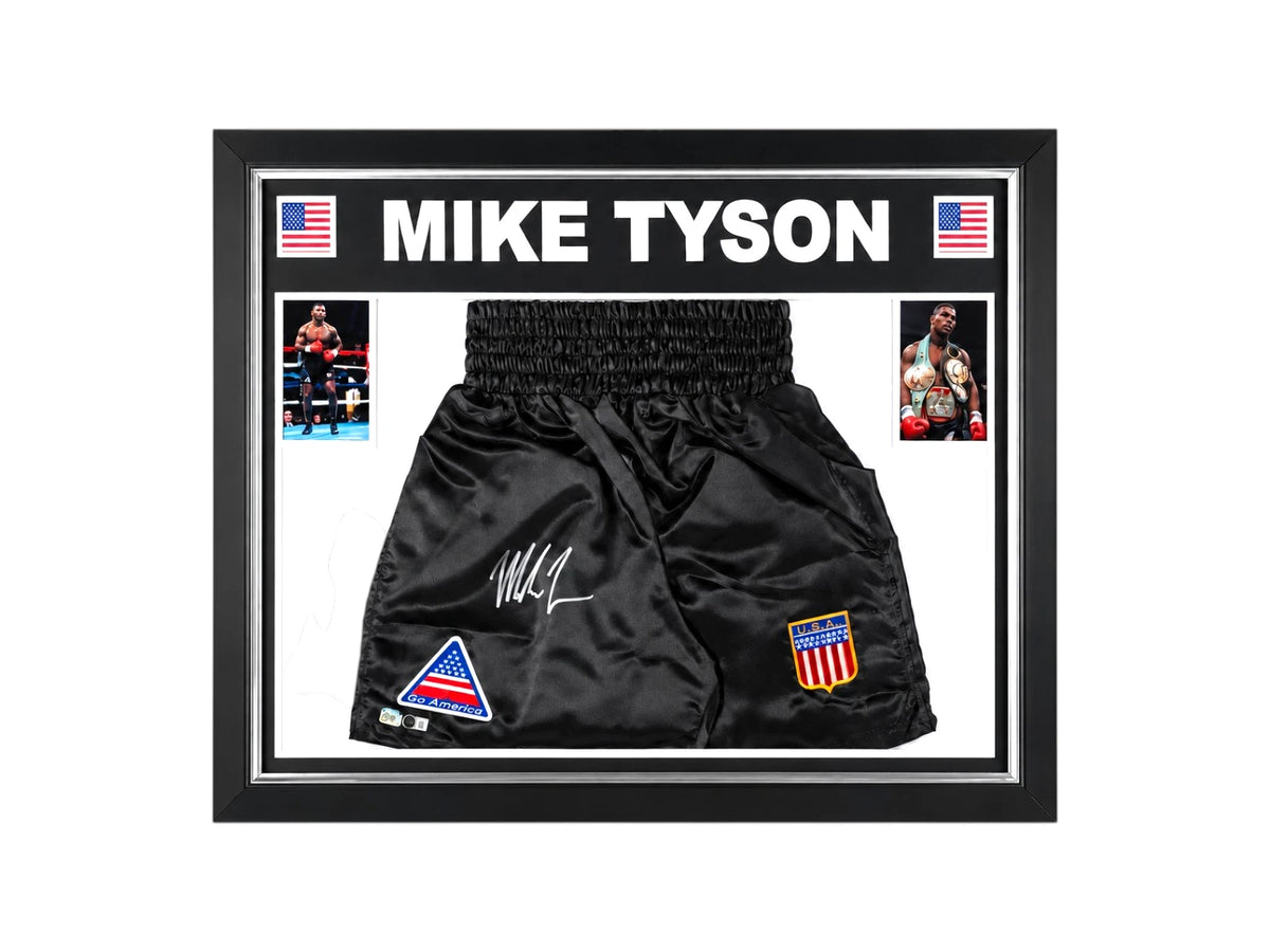 Ingelijste zwarte boksbroek gesigneerd door Mike Tyson met twee bokfoto’s en Amerikaanse vlaggen.
