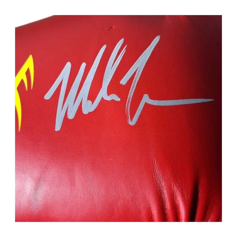Close-up van de zilverkleurige handtekening van Mike Tyson op een rode Everlast bokshandschoen.