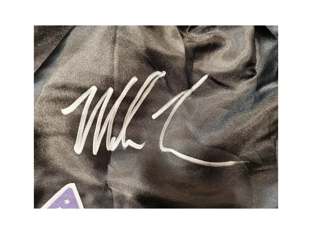 Detailfoto van de handtekening van Mike Tyson op een zwarte boksbroek.