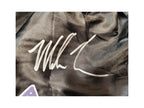 Detailfoto van de handtekening van Mike Tyson op een zwarte boksbroek.