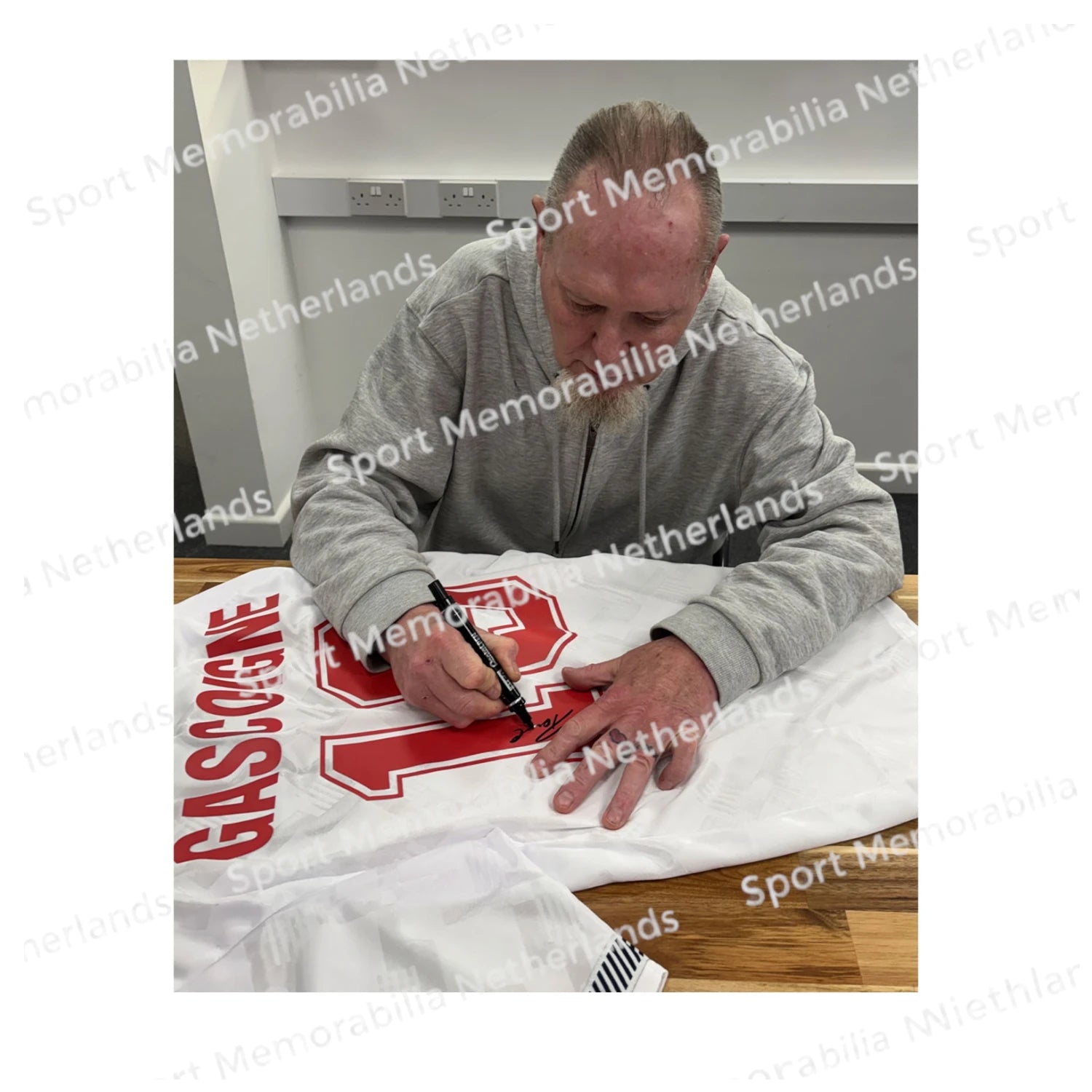 Signing proof of Paul Gascoigne signing an official England 1990 football shirt during a private signing session.