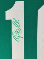 Detailfoto van de handtekening van Pelé op het witte rugnummer 10 van een groen voetbalshirt.