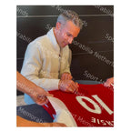 Robin van Persie tijdens het signeren van een rood Arsenal nummer 10 voetbalshirt.