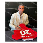 Robin van Persie tijdens het signeren van een rood Manchester United nummer 20 voetbalshirt.