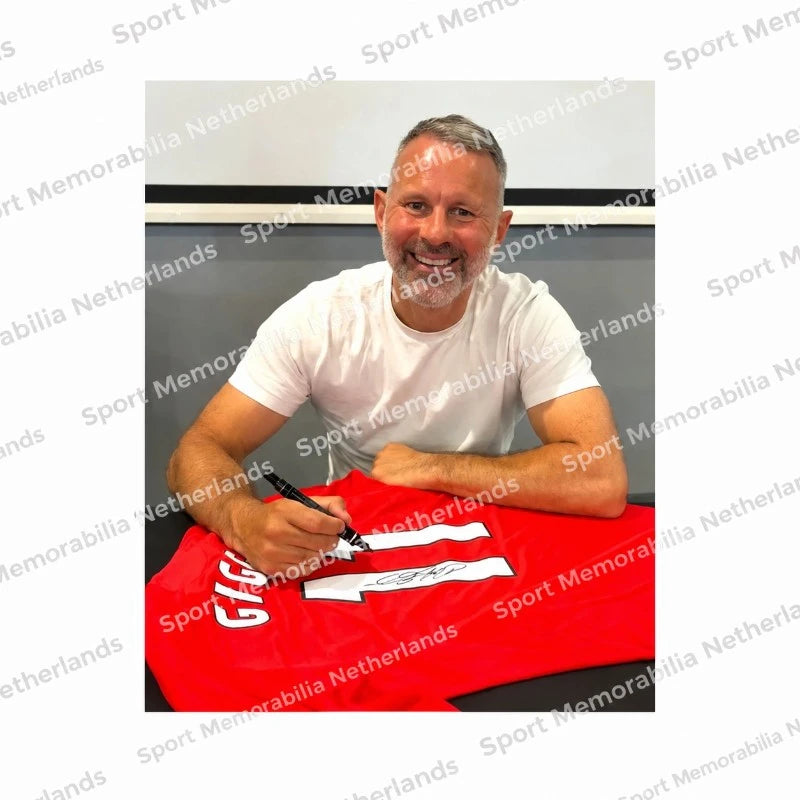 Ryan Giggs signeert een rood Manchester United voetbalshirt met rugnummer 11 tijdens een signeersessie. Authentiek signing proof van zijn handtekening.
