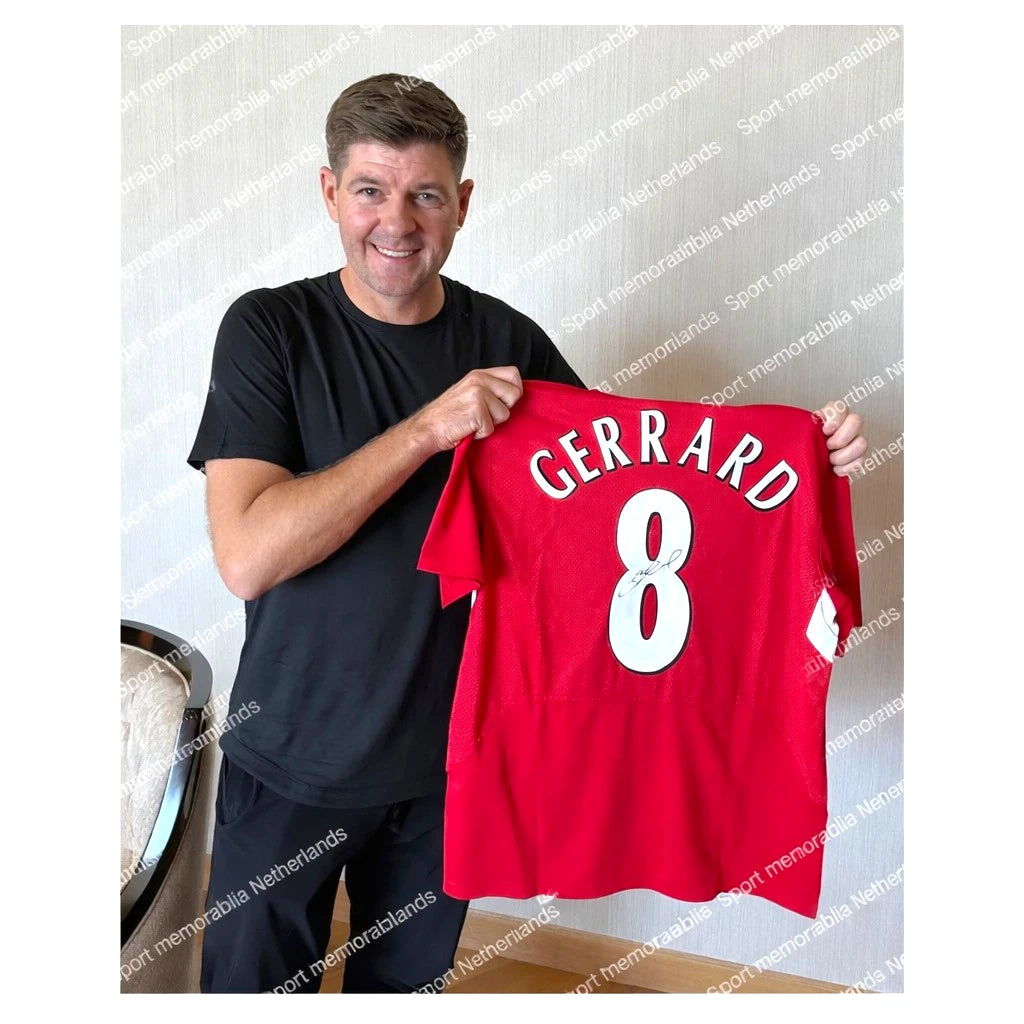 Foto van Steven Gerrard met een gesigneerd Liverpool shirt met nummer 8. Authentic signing proof voor exclusieve voetbalmemorabilia van Sport Memorabilia Netherlands.