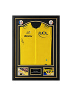 Framed Tour de France 2025 yellow jersey signed by Tadej Pogačar, professionally displayed with two cycling action photos.
