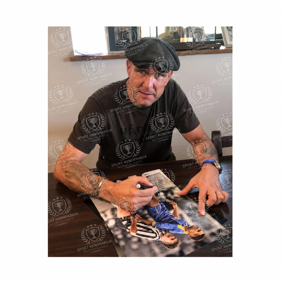 Vinnie Jones signeert een voetbalfoto met Paul Gascoigne en Vinnie Jones tijdens het signeermoment.