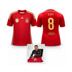 Rood Spanje nummer 8 voetbalshirt gesigneerd door Xavi Hernández, met voor- en achterkant en foto van het signeermoment.