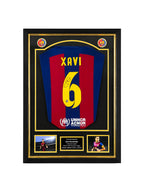 Xavi Hernandez signed FC Barcelona football shirt number 6 displayed in a black and gold presentation frame.